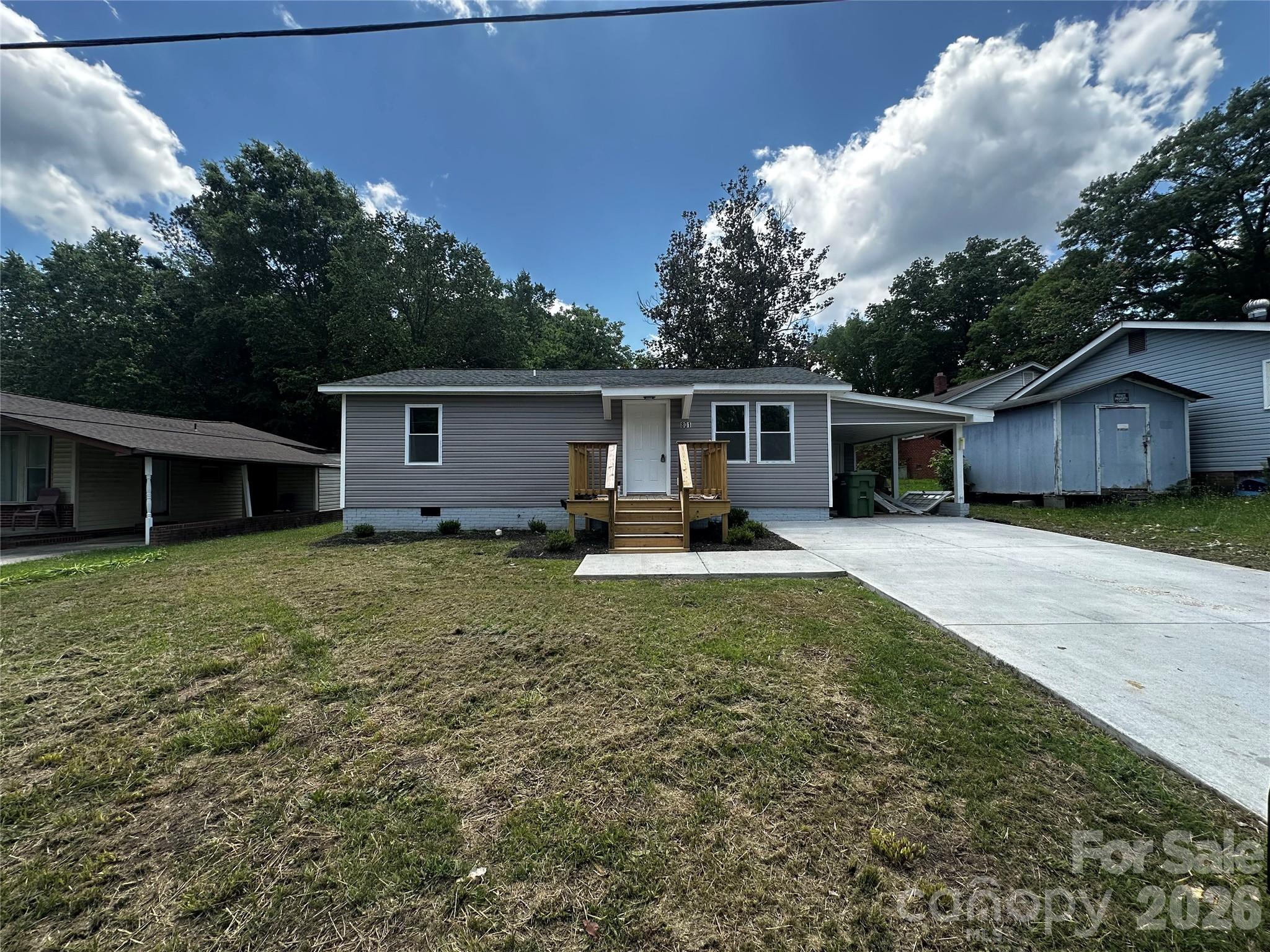 a view of a house with backyard and a tree
