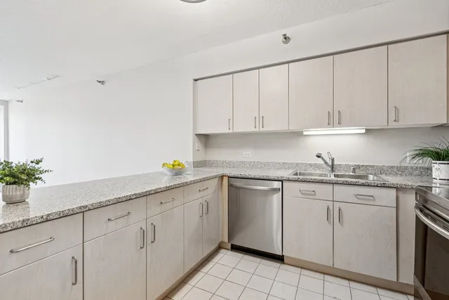 a kitchen with granite countertop white cabinets white appliances and a sink