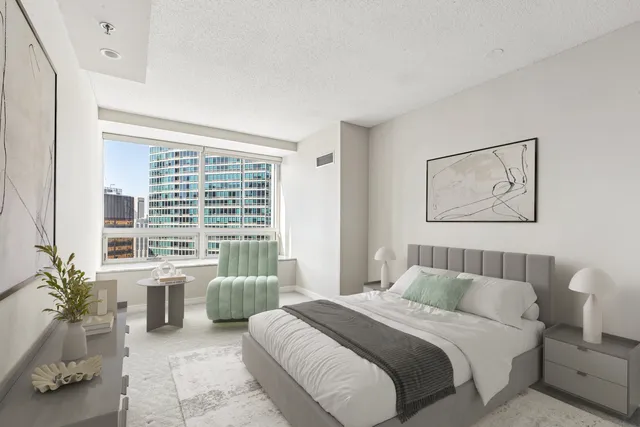 a spacious bedroom with a bed a couch and a potted plant