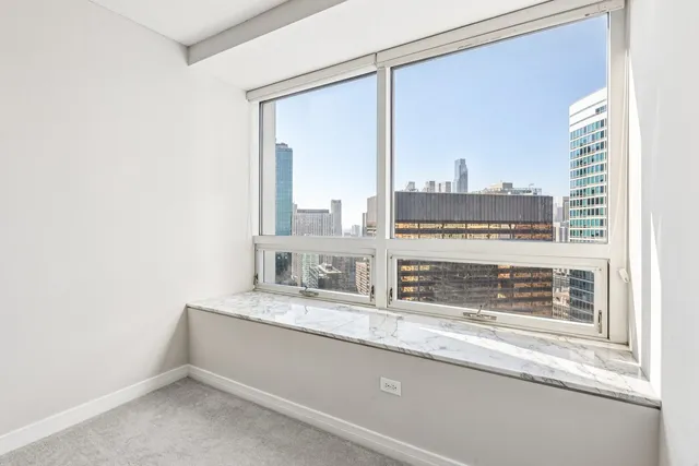 a bathroom with a granite countertop sink and a large mirror next to a window