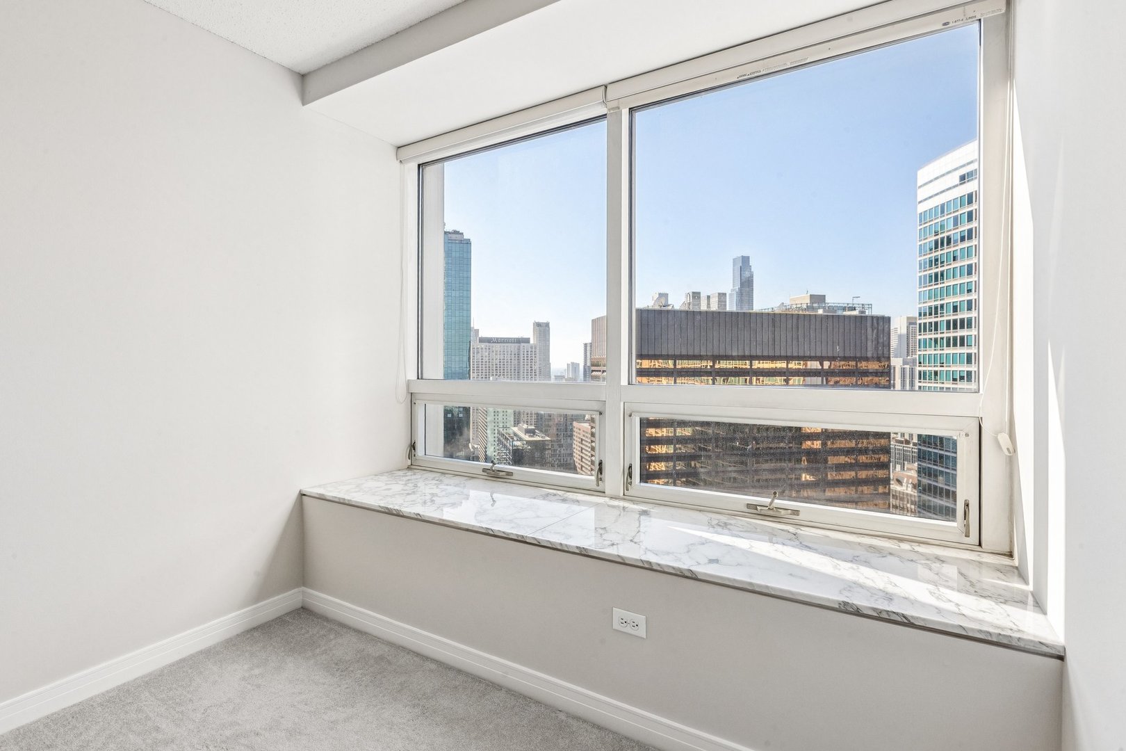512 North McClurg Court, Unit 3312 Chicago, IL 60611 - Photo 25 of 47 a bathroom with a granite countertop sink and a large mirror next to a window