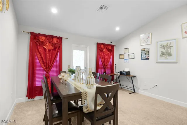 a kitchen with refrigerator and chairs