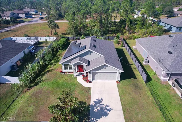 an aerial view of residential houses with outdoor space and swimming pool