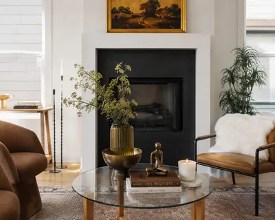 a living room with furniture a fireplace and a potted plant