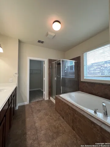 a spacious bathroom with a granite countertop tub shower and mirror