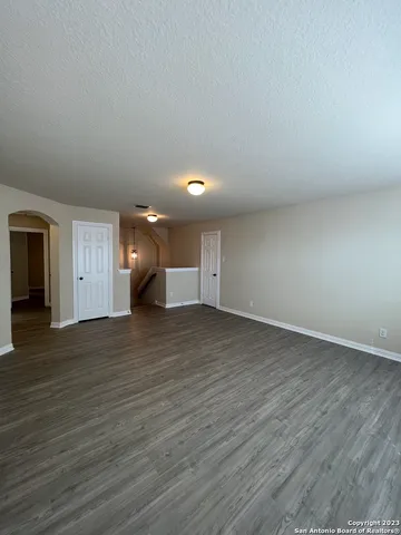a view of empty room with wooden floor