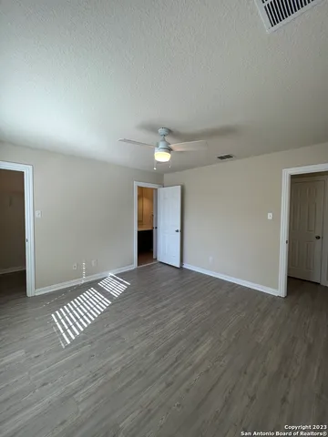 a view of an empty room with wooden floor and closet