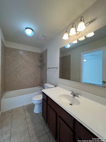 a bathroom with a sink a toilet a mirror and bathtub