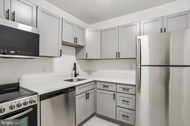 a kitchen with appliances a sink and cabinets