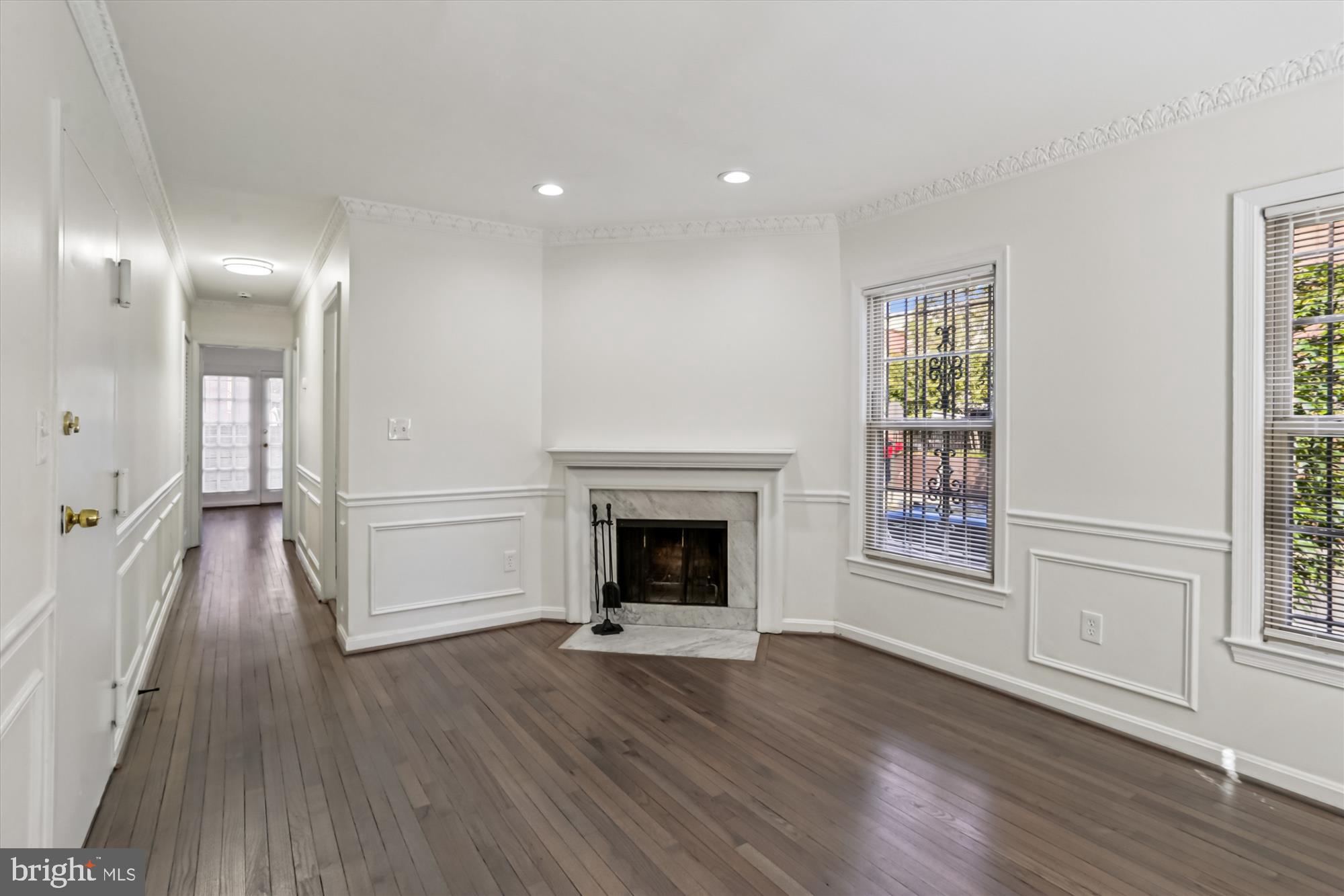 1690 Euclid Street Northwest, Unit A Washington, DC 20009 - Photo 17 of 38 an empty room with wooden floor fireplace and windows