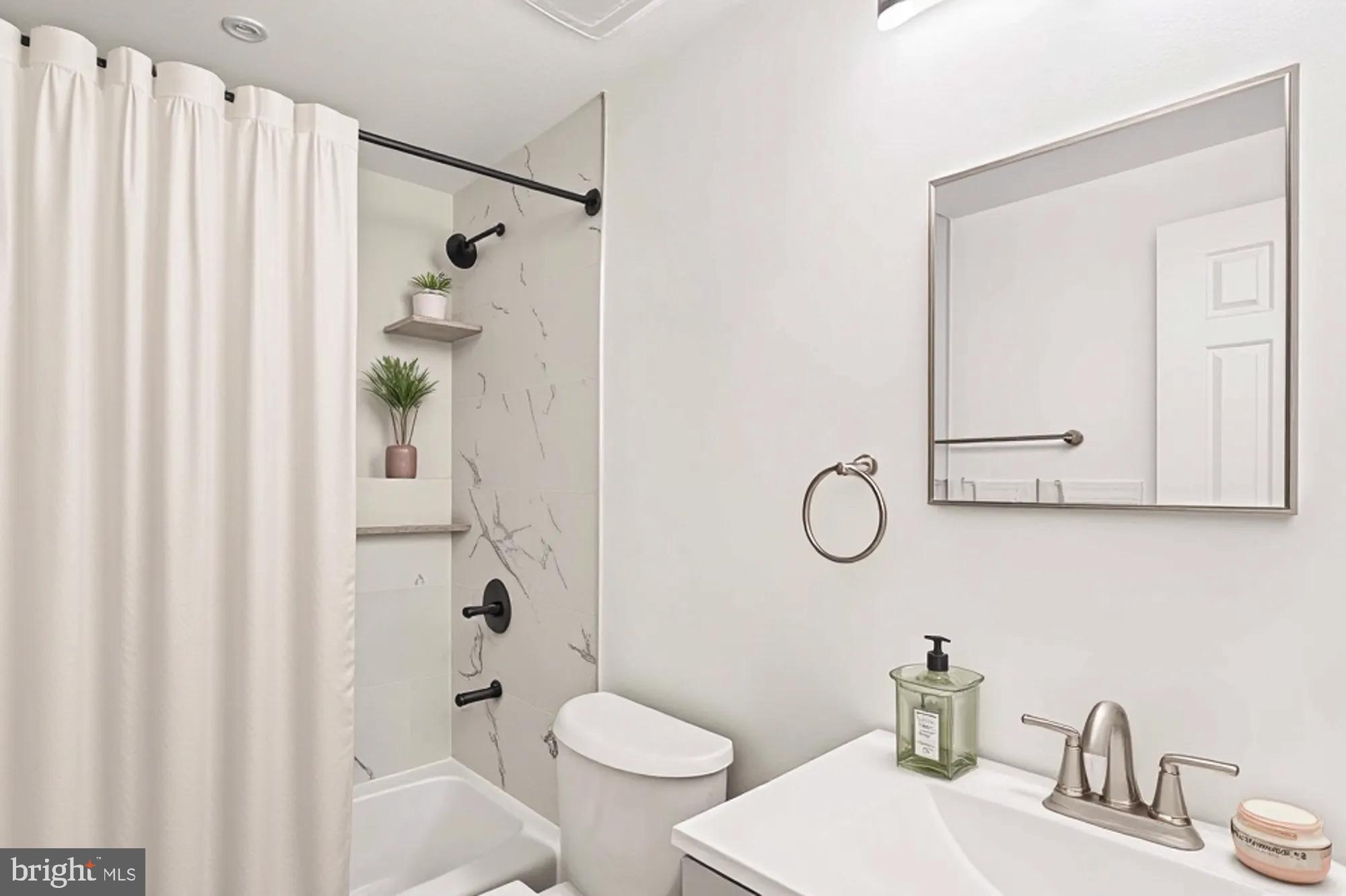 1690 Euclid Street Northwest, Unit A Washington, DC 20009 - Photo 5 of 38 a bathroom with a sink a toilet and shower curtain