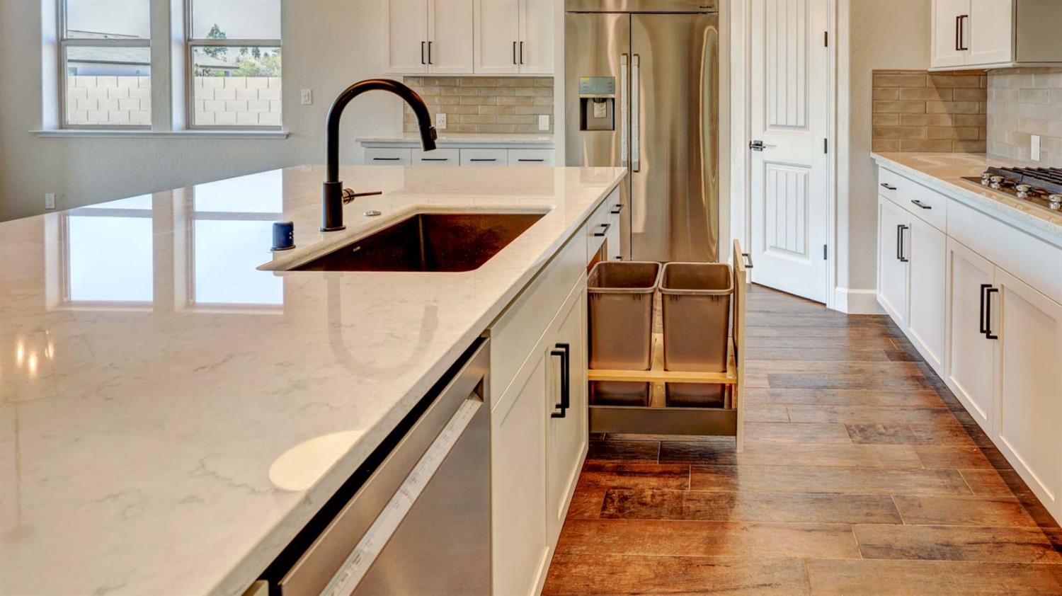 1742 North Applegate Avenue Clovis, CA 93619 - Photo 13 of 31 a kitchen with kitchen island a counter top a stove a chimney and a sink with wooden floor