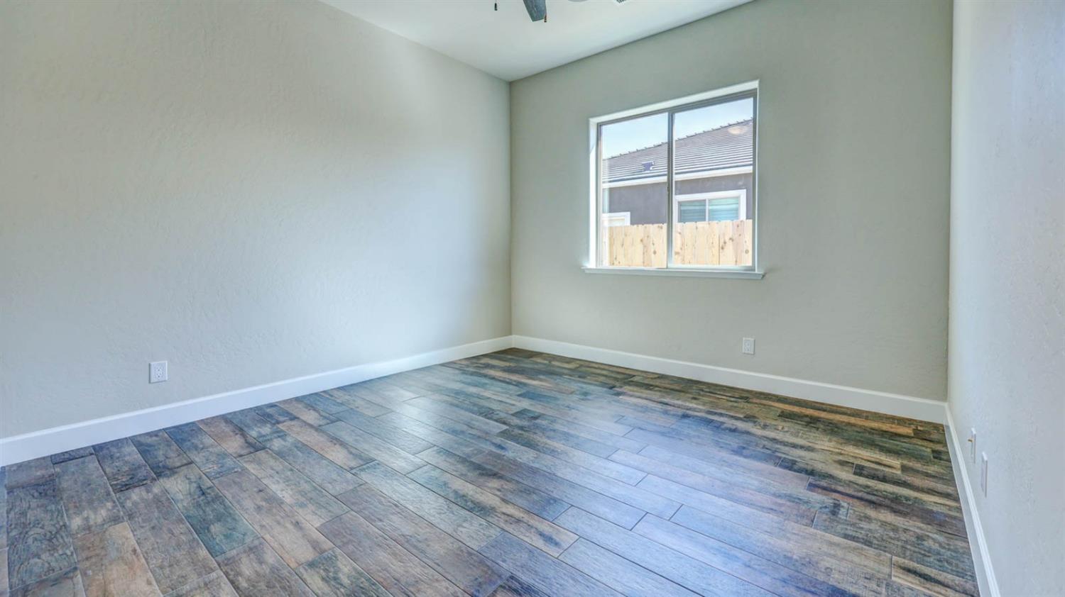 1742 North Applegate Avenue Clovis, CA 93619 - Photo 5 of 31 an empty room with wooden floor and windows