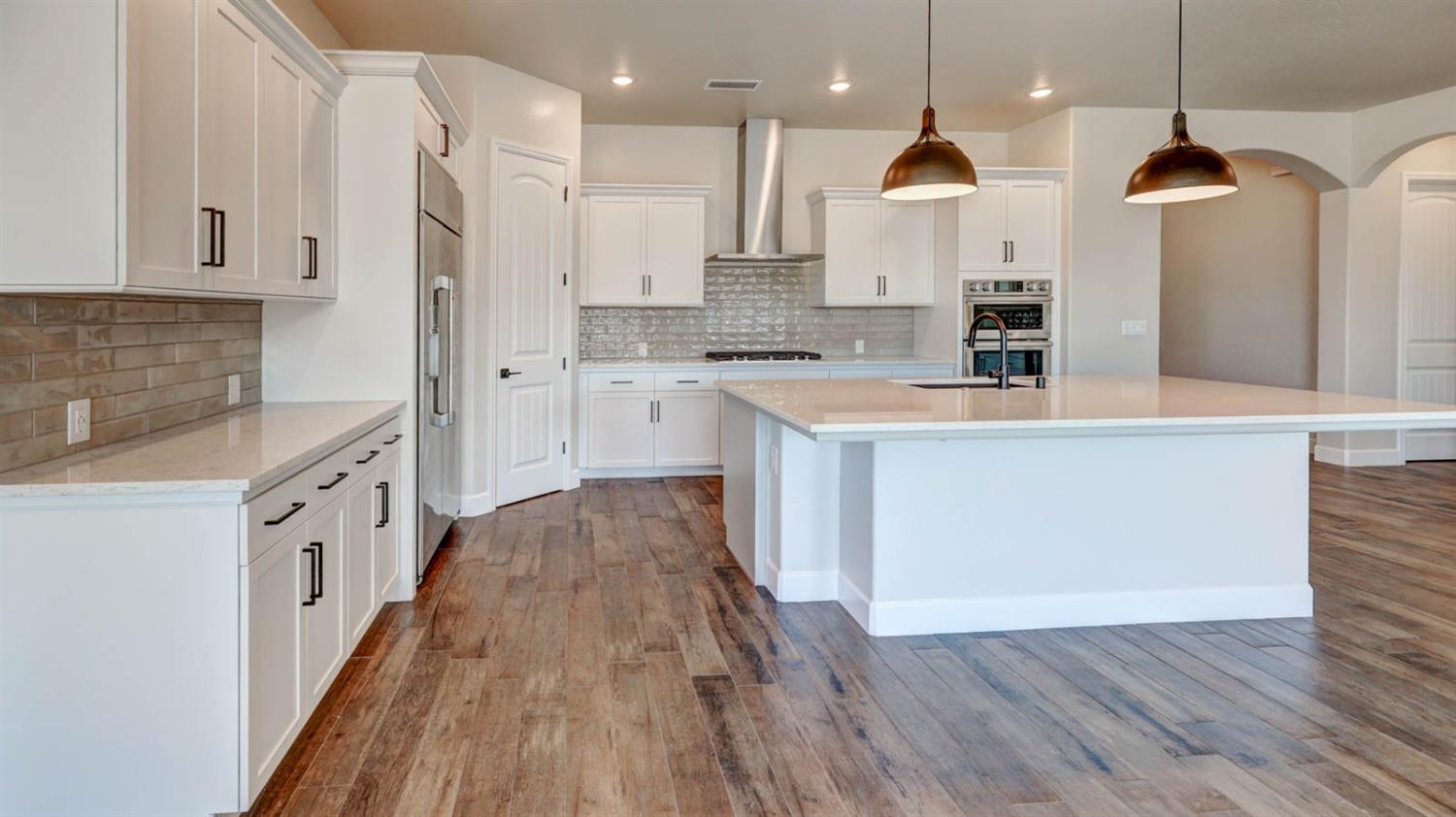 1742 North Applegate Avenue Clovis, CA 93619 - Photo 8 of 31 a large kitchen with stainless steel appliances kitchen island granite countertop a stove a sink a refrigerator and a wooden floors