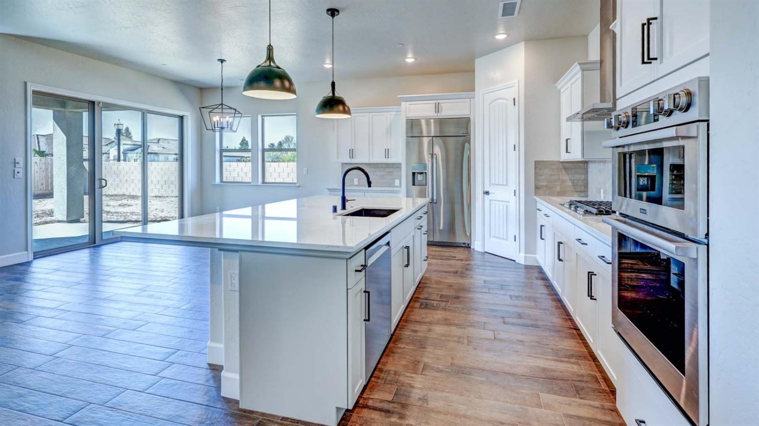1742 North Applegate Avenue Clovis, CA 93619 - Photo 9 of 31 a large kitchen with stainless steel appliances granite countertop a lot of counter space and wooden floor