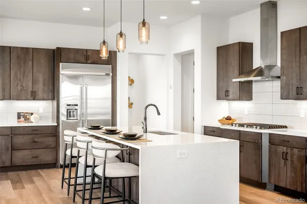 a kitchen with stainless steel appliances a stove a sink a refrigerator and a refrigerator