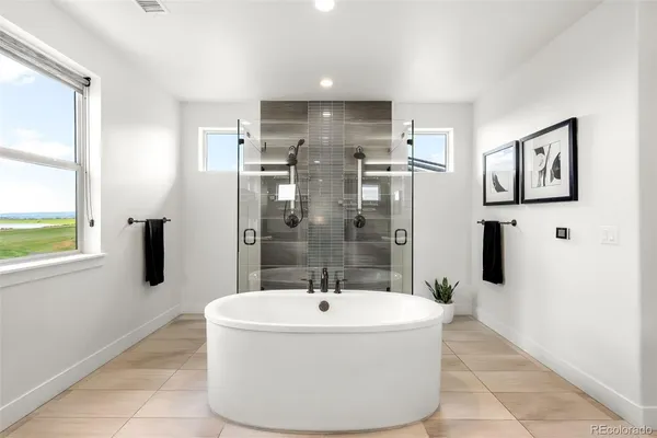 a spacious bathroom with a granite countertop sink a mirror and a bathtub