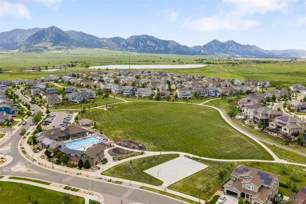 an aerial view of residential houses with outdoor space and lake view