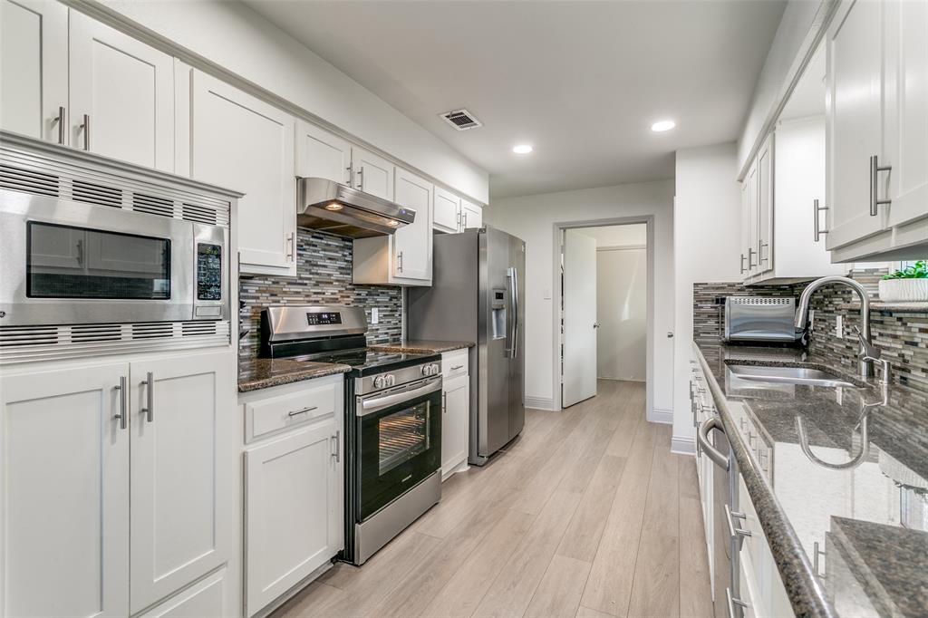 2922 Ridgewood Drive Grapevine, TX 76051 - Photo 11 of 25 a kitchen with stainless steel appliances a stove sink microwave and cabinets