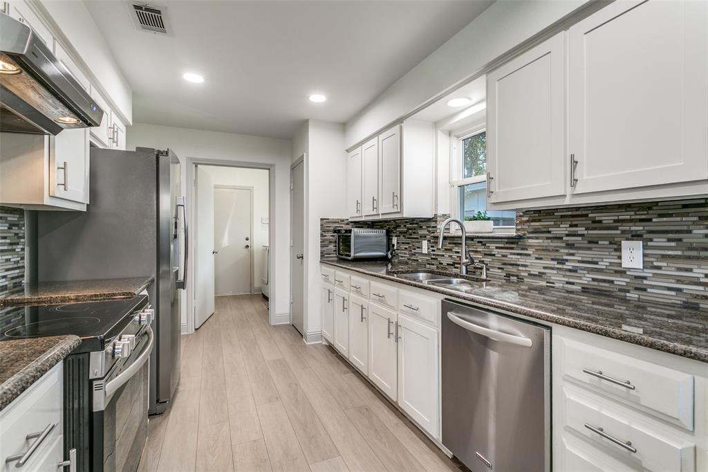 2922 Ridgewood Drive Grapevine, TX 76051 - Photo 12 of 25 a kitchen with stainless steel appliances granite countertop a stove a sink and a refrigerator