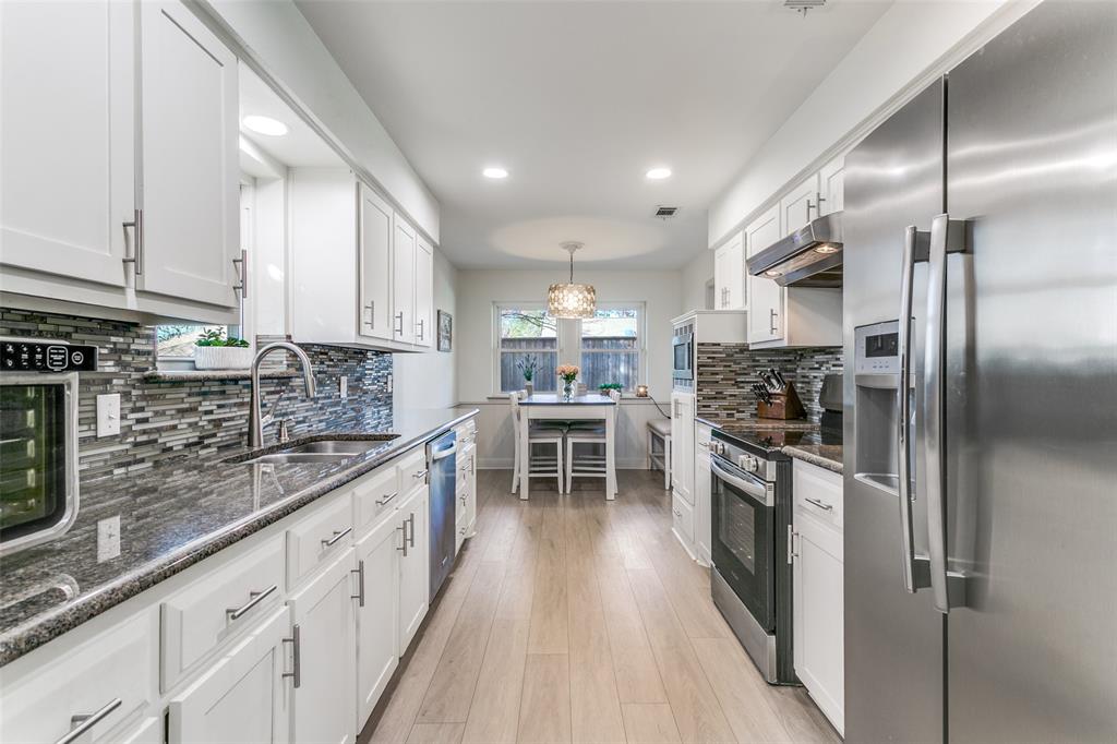 2922 Ridgewood Drive Grapevine, TX 76051 - Photo 13 of 25 a kitchen with kitchen island granite countertop lots of counter top space and stainless steel appliances