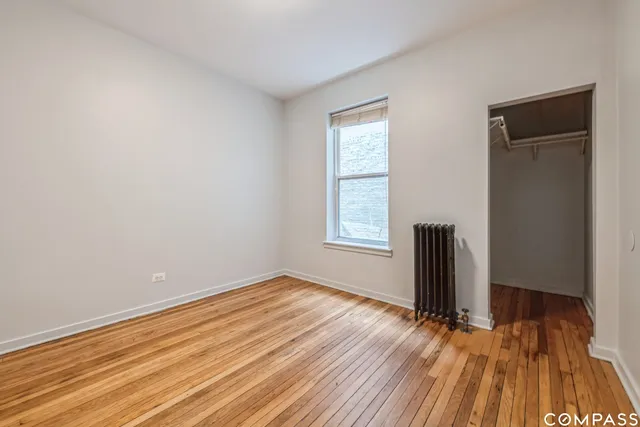 an empty room with wooden floor and a window