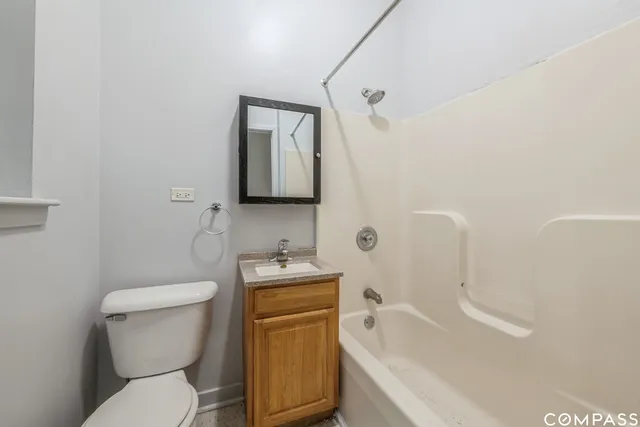 a white toilet sitting next to a bathroom sink and tub