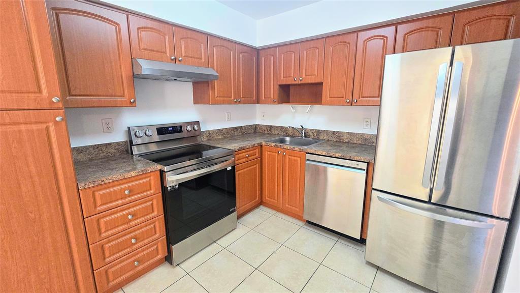 8401 West Sample Road, Unit 48 Coral Springs, FL 33065 - Photo 1 of 26 a kitchen with stainless steel appliances granite countertop a refrigerator stove and sink