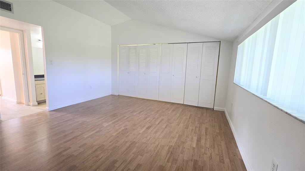 8401 West Sample Road, Unit 48 Coral Springs, FL 33065 - Photo 23 of 26 an empty room with wooden floor and windows