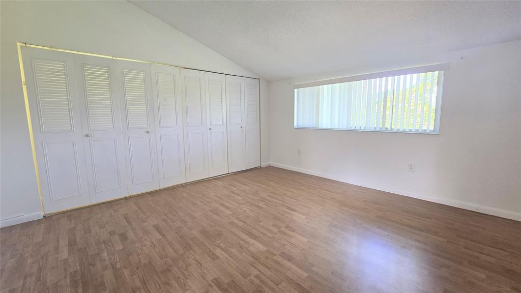 8401 West Sample Road, Unit 48 Coral Springs, FL 33065 - Photo 24 of 26 a view of an empty room with wooden floor and a window