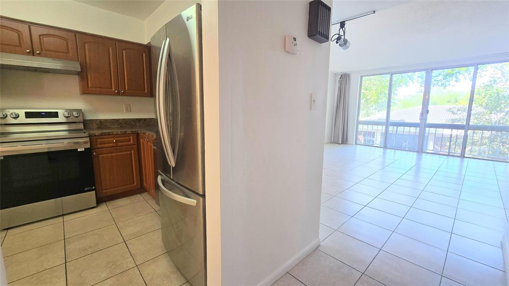 8401 West Sample Road, Unit 48 Coral Springs, FL 33065 - Photo 3 of 26 a kitchen with stainless steel appliances a stove a sink and a refrigerator