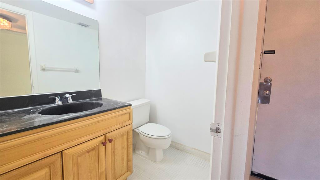 8401 West Sample Road, Unit 48 Coral Springs, FL 33065 - Photo 6 of 26 a bathroom with a granite countertop sink toilet and a mirror