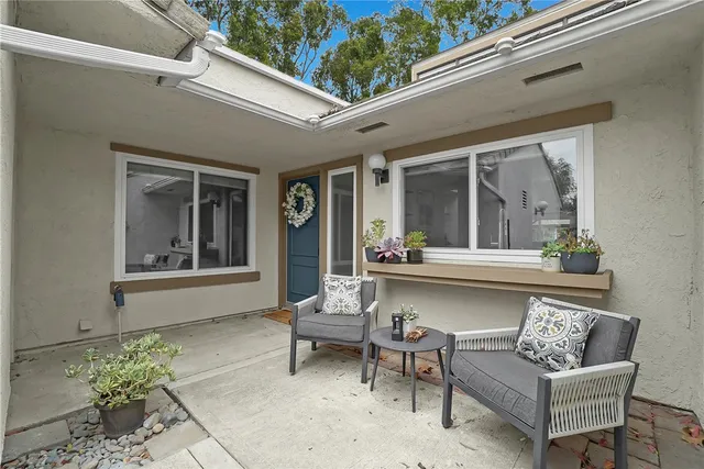 a view of a patio with couches table and chairs and potted plants