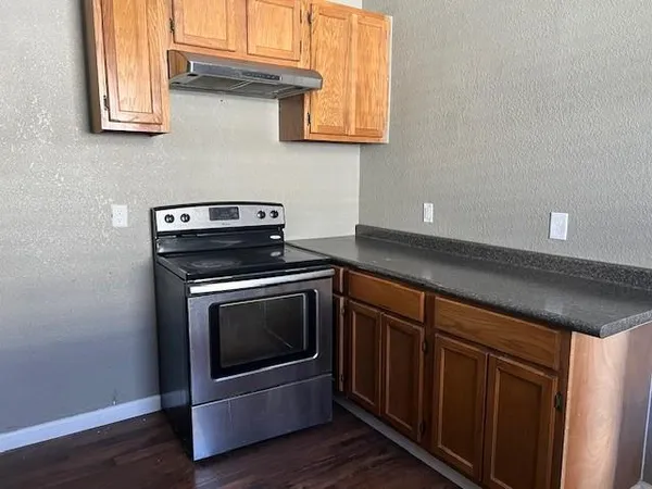 a kitchen with granite countertop a stove and a microwave