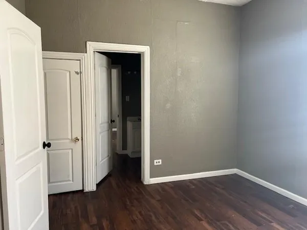 an empty room with wooden floor and closet