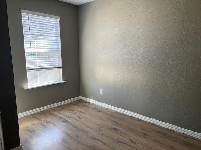 714 North Commerce Street Gainesville, TX 76240 - Photo 17 of 19 a view of an empty room with wooden floor and a window