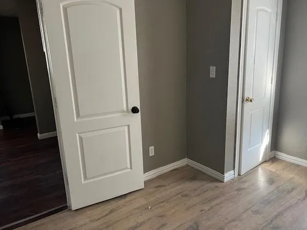 an empty room with wooden floor and closet