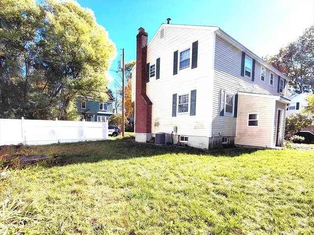 a view of a white house with a big yard