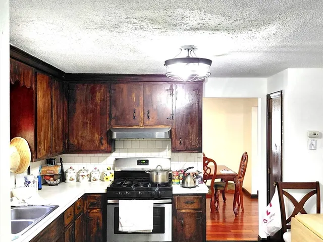 a kitchen with stainless steel appliances wooden cabinets and a stove top oven