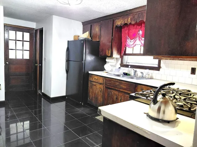 a kitchen with a refrigerator and a stove