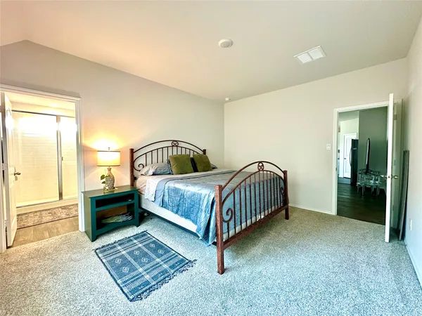 a bedroom with a bed lamp and a dresser