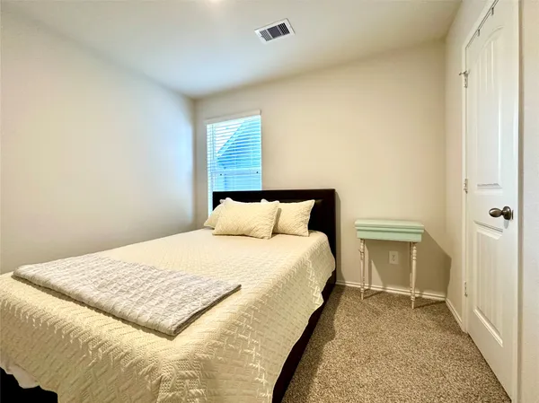 a bed sitting in a bedroom next to a bathroom