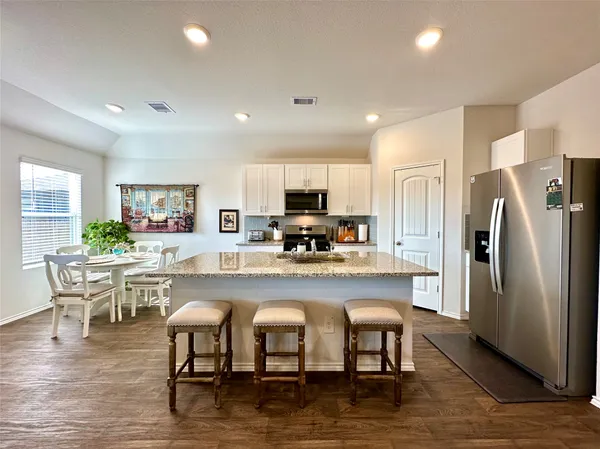 a kitchen with a table chairs refrigerator and cabinets