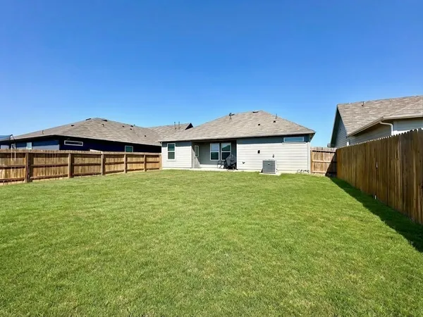 a backyard of a house with table and chairs