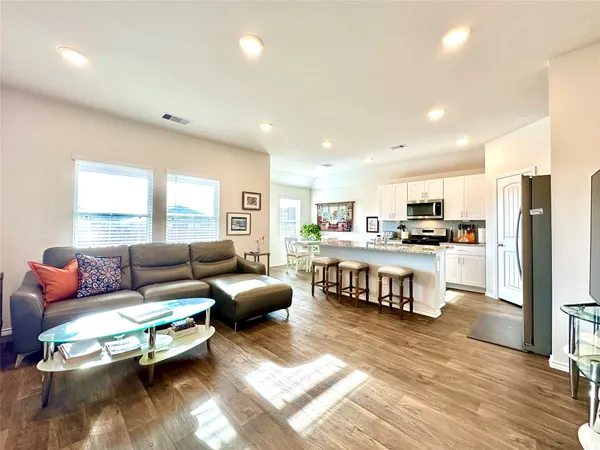 a living room with kitchen island furniture and a kitchen view