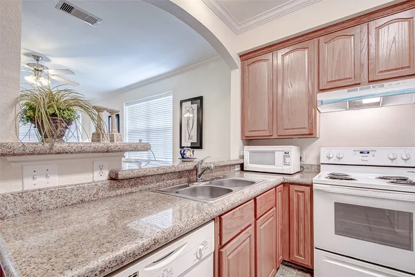 a kitchen with stainless steel appliances granite countertop a sink a stove and cabinets