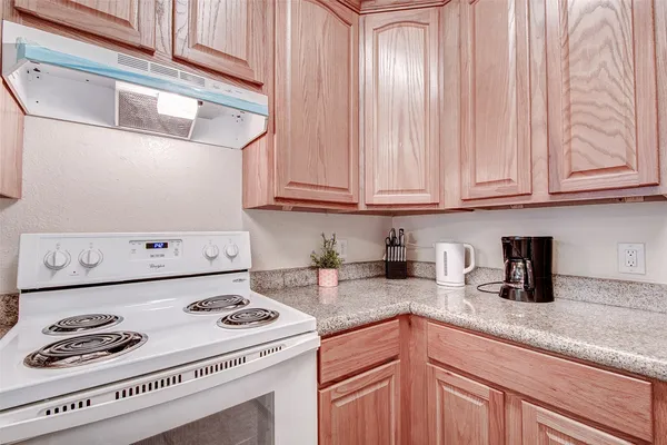 a kitchen with a sink a stove and cabinets