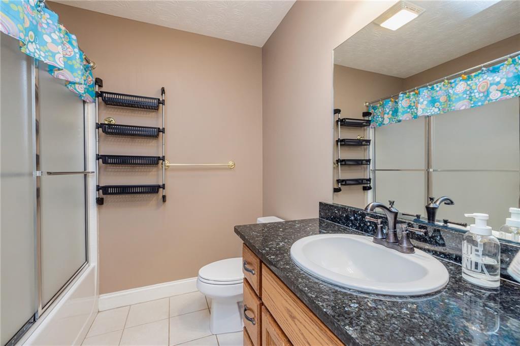 394 South Alexander Creek Road Newnan, GA 30263 - Photo 45 of 76 a bathroom with a granite countertop sink a toilet a mirror and shower