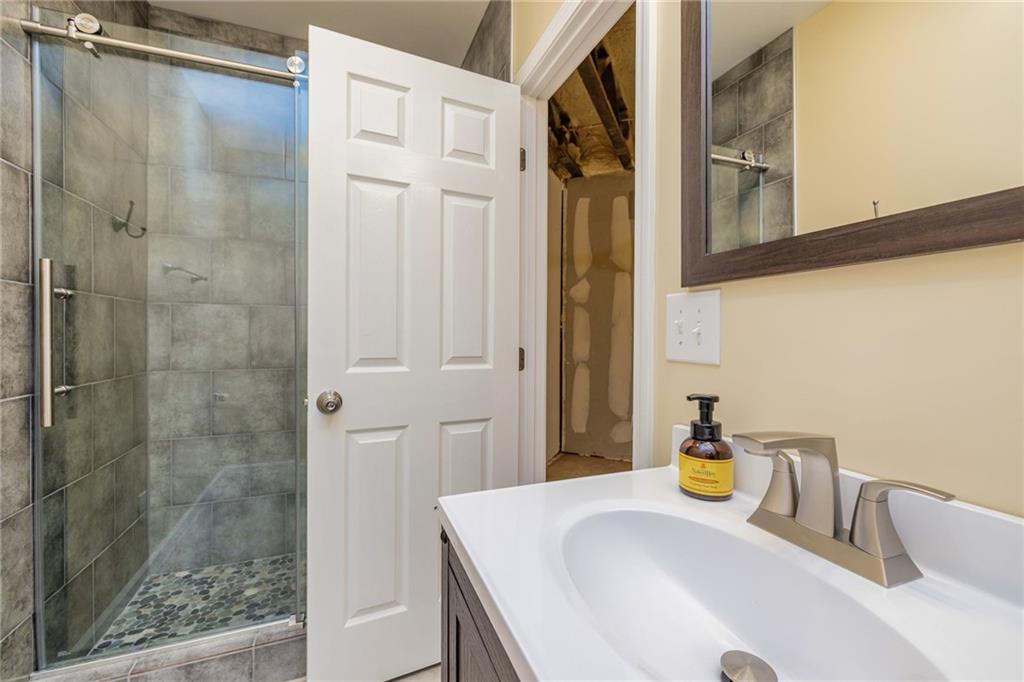 394 South Alexander Creek Road Newnan, GA 30263 - Photo 49 of 76 a bathroom with a granite countertop sink a mirror and shower