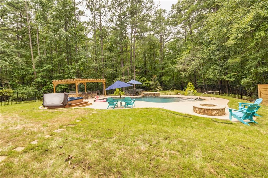 394 South Alexander Creek Road Newnan, GA 30263 - Photo 60 of 76 a view of a swimming pool with lawn chairs and large trees